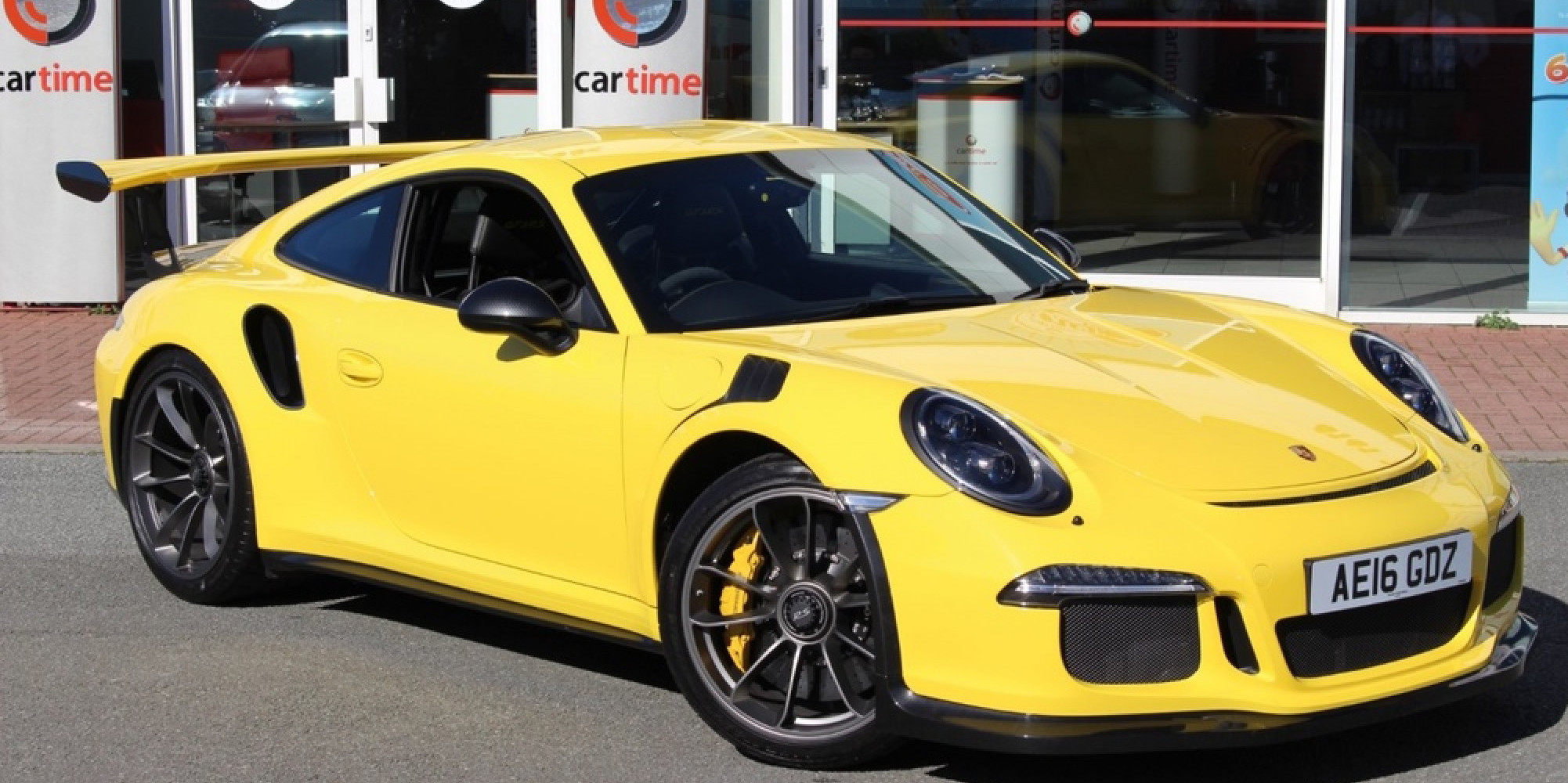 Yellow Porsche 911 parked three-quarters facing right